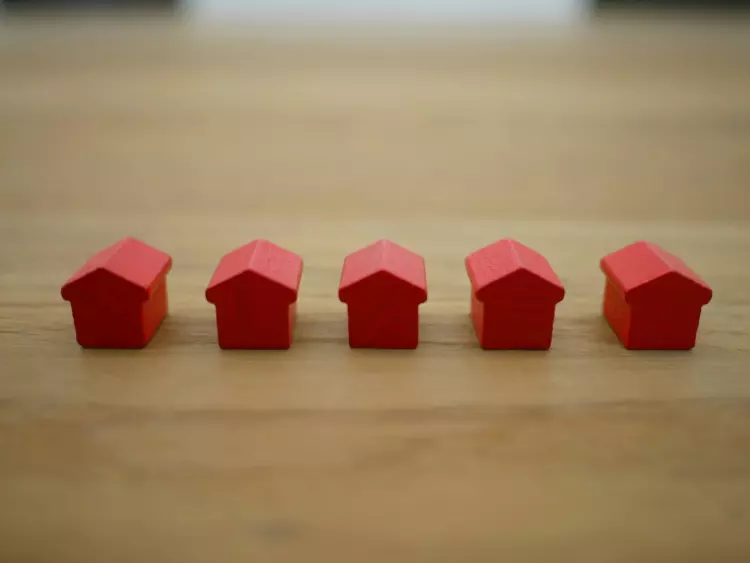 five red toy houses in a line