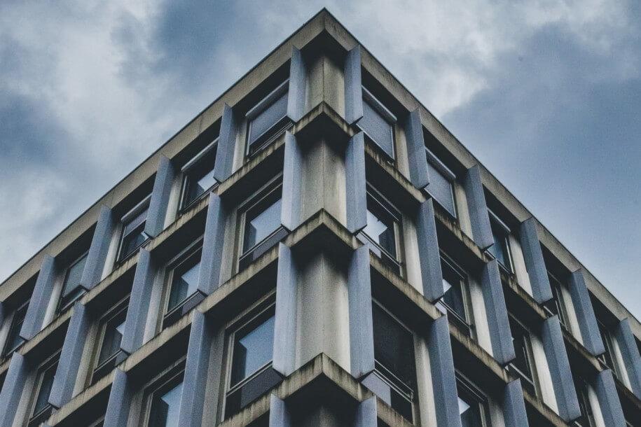 vertical low angle shot blue gray building cloudy sky