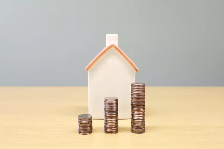 Small house with stacks of coins infront of it